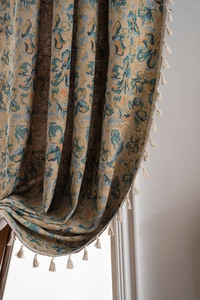 Detailed close-up of jacquard floral pattern and elegant cream tassels on curtain edge