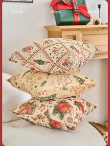 Dettaglio di tre spessi cuscini jacquard natalizi con motivi di alberi e campanelli