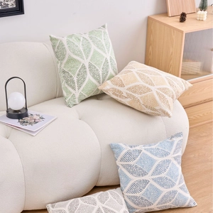 Set of modern geometric cushion covers in green, blue and beige on a stylish sofa