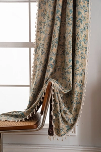 Detail of vintage floral jacquard fabric with tassels draped on a woven chair