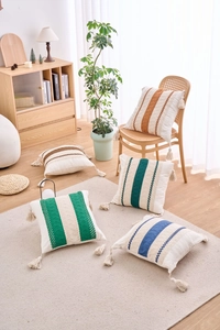 Detail showing colorful geometric bohemian throw pillow covers with tassels in a cozy room