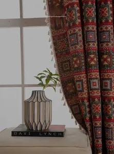 Detail of red geometric curtains with white tassels providing 50% shading for windows