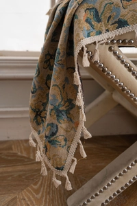 Detail of jacquard curtain fabric with retro floral pattern and fringed tassels