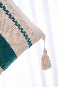 Close-up of bohemian green and beige woven pillowcase with crochet lace and soft tassel