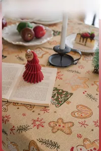 Detail of Christmas tablecloth featuring gingerbread men and tree embroidery