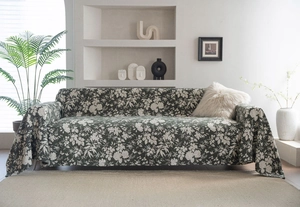 Detailed close-up of a dark green floral sofa cover with realistic white flower patterns