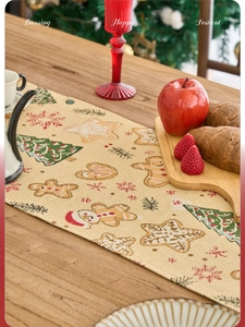 Detailstruktur des Weihnachts-Tischläufers mit Lebkuchenmann-Motiv auf einem Holztisch