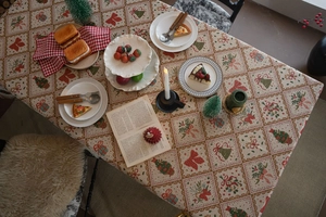 Detailed close-up of Christmas themed jacquard tablecloth with festive bow and tree patterns