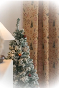 Detailed view of Christmas curtain with gingerbread man patterns and white tassels