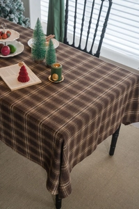 Détail de la nappe épaisse à carreaux marron avec décoration de table de Noël rustique