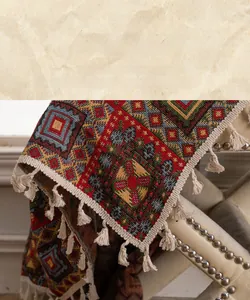 Detail of red geometric jacquard fabric with cream handmade tassel trim edges