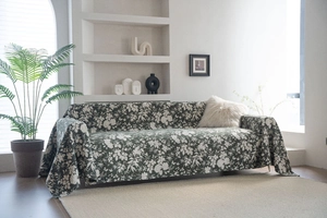 Detail of dark green floral jacquard sofa cover with white blossom patterns on thick fabric