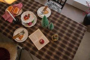 Gros plan sur la nappe à carreaux marron café et le décor de table hivernal