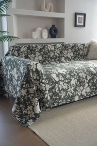 Detail of dark green floral sofa throw blanket with premium textured fabric in a modern home