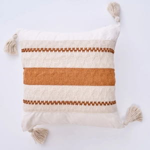 Close-up of bohemian pillowcase with woven geometric patterns and corner tassels