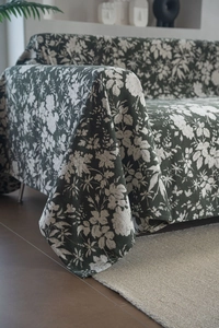 Close-up of thick dark green sofa cover fabric with white floral patterns and texture