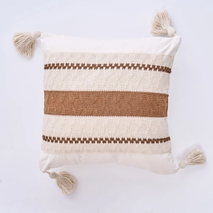 Detail of woven boho cushion cover featuring geometric stripes and corner tassels