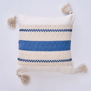 Detail view of bohemian pillowcase with blue knit stripes and decorative tassels