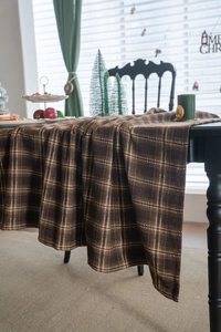 Gros plan sur une nappe épaisse à carreaux marron, texture premium pour Noël raffiné
