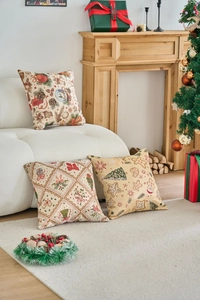 Vista dettagliata di tre cuscini natalizi in jacquard con motivi festivi classici e colori
