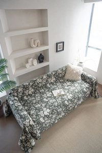 Close-up of dark green floral sofa cover with white botanical patterns in minimalist room