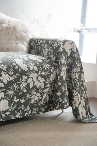 Close-up of thick woven floral fabric in dark green showing texture and leaf patterns