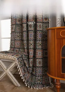 Detail of bohemian geometric jacquard curtain fabric with decorative white cotton tassels