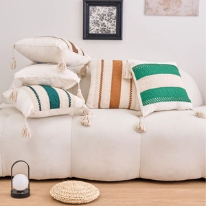 Minimalist boho knit pillow covers with colorful stripes and tassels on a sofa