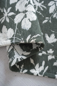 Close-up of jacquard floral fabric showing thick texture and double-sided green patterns