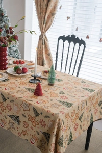Detailed view of jacquard Christmas tablecloth featuring gingerbread man and tree patterns