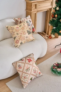 Vista dettagliata dei cuscini natalizi jacquard con omino di pan di zenzero e decori