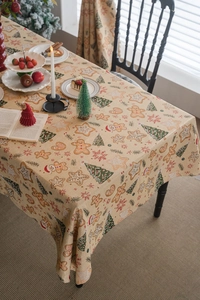 Detail of gingerbread man Christmas tablecloth with star and tree patterns on woven fabric