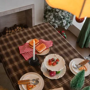 Nappe à carreaux marron épais sur table de fête avec sapin de Noël en arrière-plan