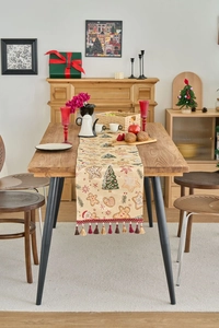 Detail eines Weihnachts-Tischläufers mit Lebkuchenmann-Jacquard und bunten Quasten