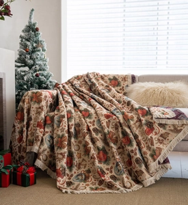 Detailed Christmas throw blanket with pinecone jacquard patterns and cream tassels on a sofa