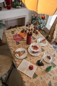 Detail of Christmas tablecloth featuring gingerbread men and trees in a festive home setting