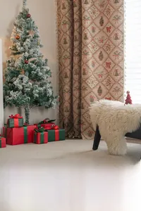 Detail of Christmas jacquard curtain with festive tree and bow patterns in a cozy room