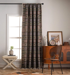 Detail of bohemian geometric jacquard curtain fabric with decorative fringe tassels