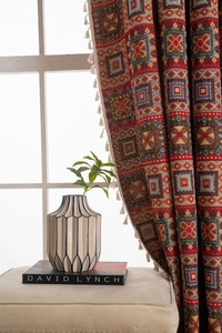 Detail of red geometric jacquard curtain fabric with white cotton tassel fringe edges