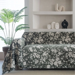 Floral dark green sofa cover with white blossom patterns in minimalist interior setting