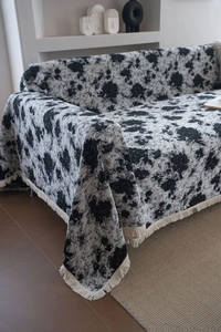 Gros plan sur la couverture de canapé jacquard noir et blanc avec franges décoratives