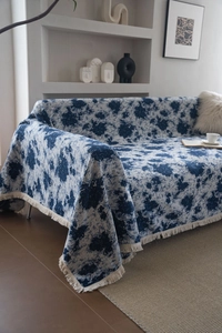 Detailed texture of thick blue jacquard floral sofa cover with white decorative tassels