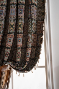 Detailed view of bohemian geometric jacquard fabric with elegant tassel trim decoration