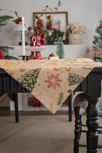 Close-up of woven jacquard tablecloth featuring gingerbread men and Christmas tree patterns