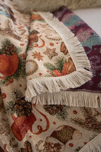 Close-up of Christmas jacquard woven blanket with pine cones, stars and tassel edge