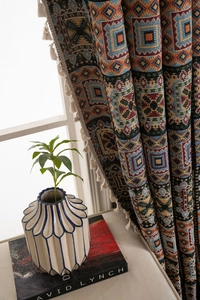 Detail of bohemian geometric jacquard fabric with colorful patterns and white tassel fringe