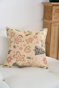 Dettaglio di un cuscino natalizio in jacquard con pan di zenzero su divano bianco