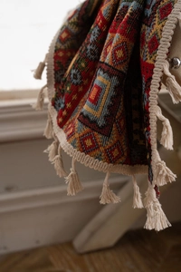 Detail of bohemian red geometric jacquard fabric with cream tassel fringe edges