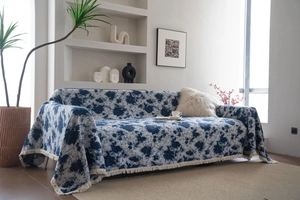 Close-up of thick blue jacquard sofa cover with fringe details and vintage pattern