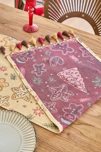 Detail eines Weihnachts-Tischläufers mit Lebkuchenmann-Jacquard und Quasten